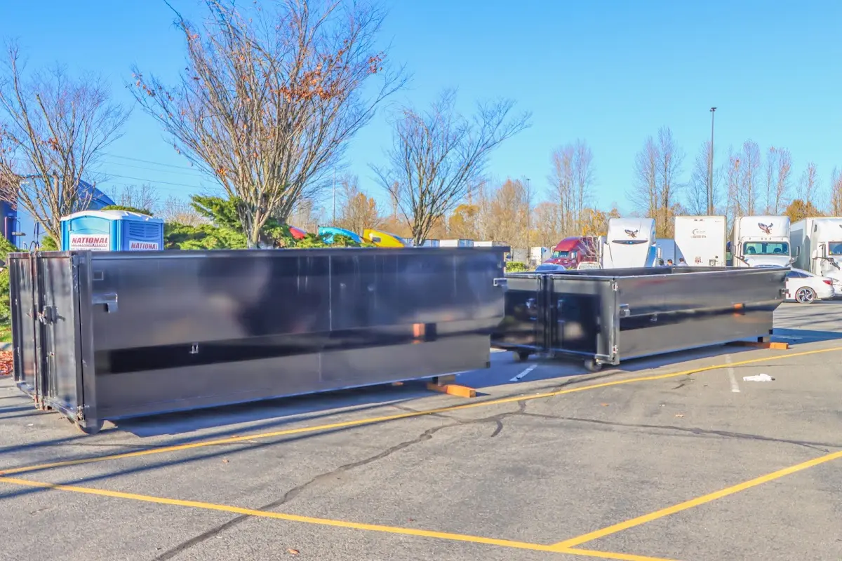 Professional dumpster rental service with roll-off container on residential driveway in Charles City